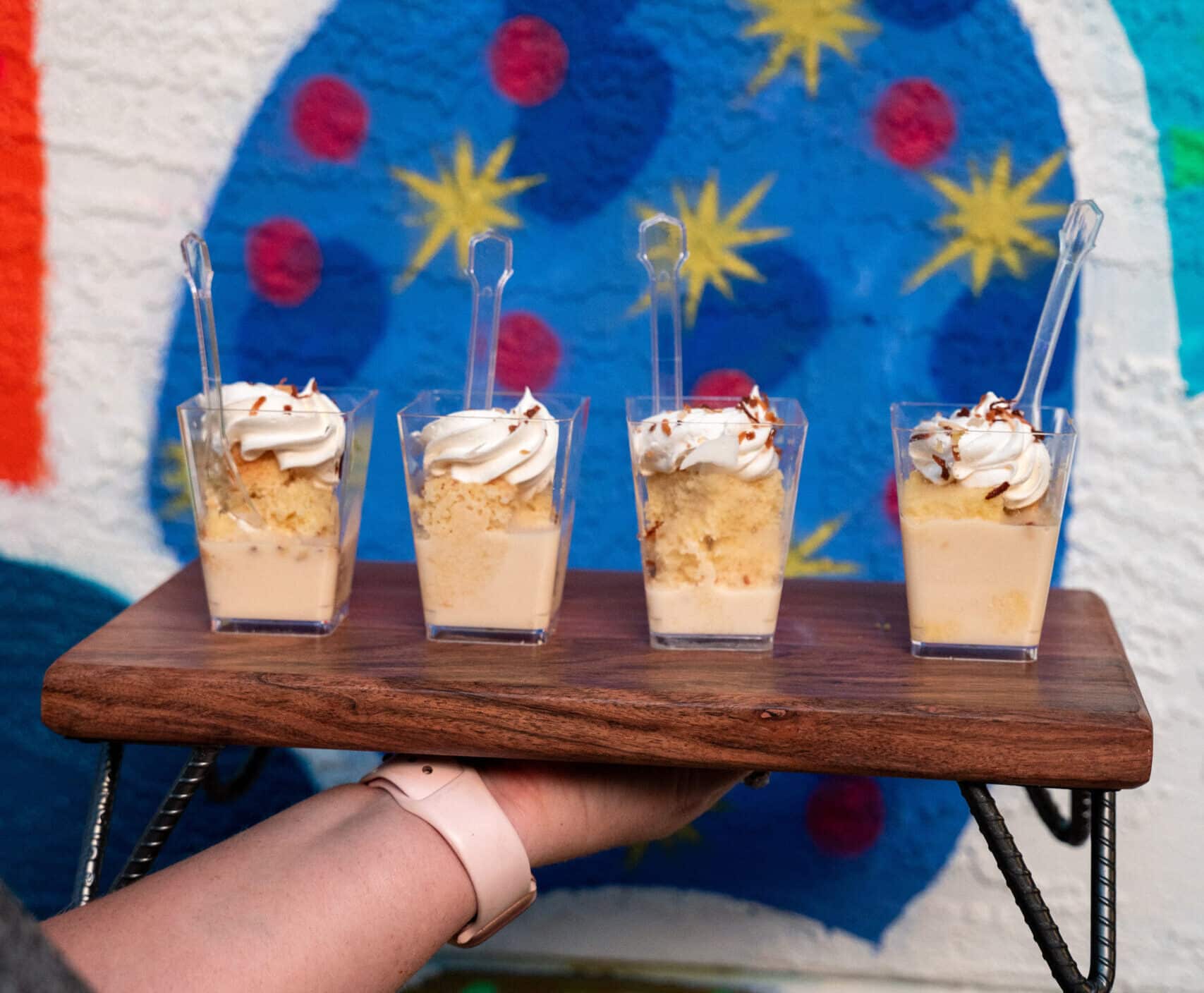 Woman Holding Tray With Four Tres Leches Shooters